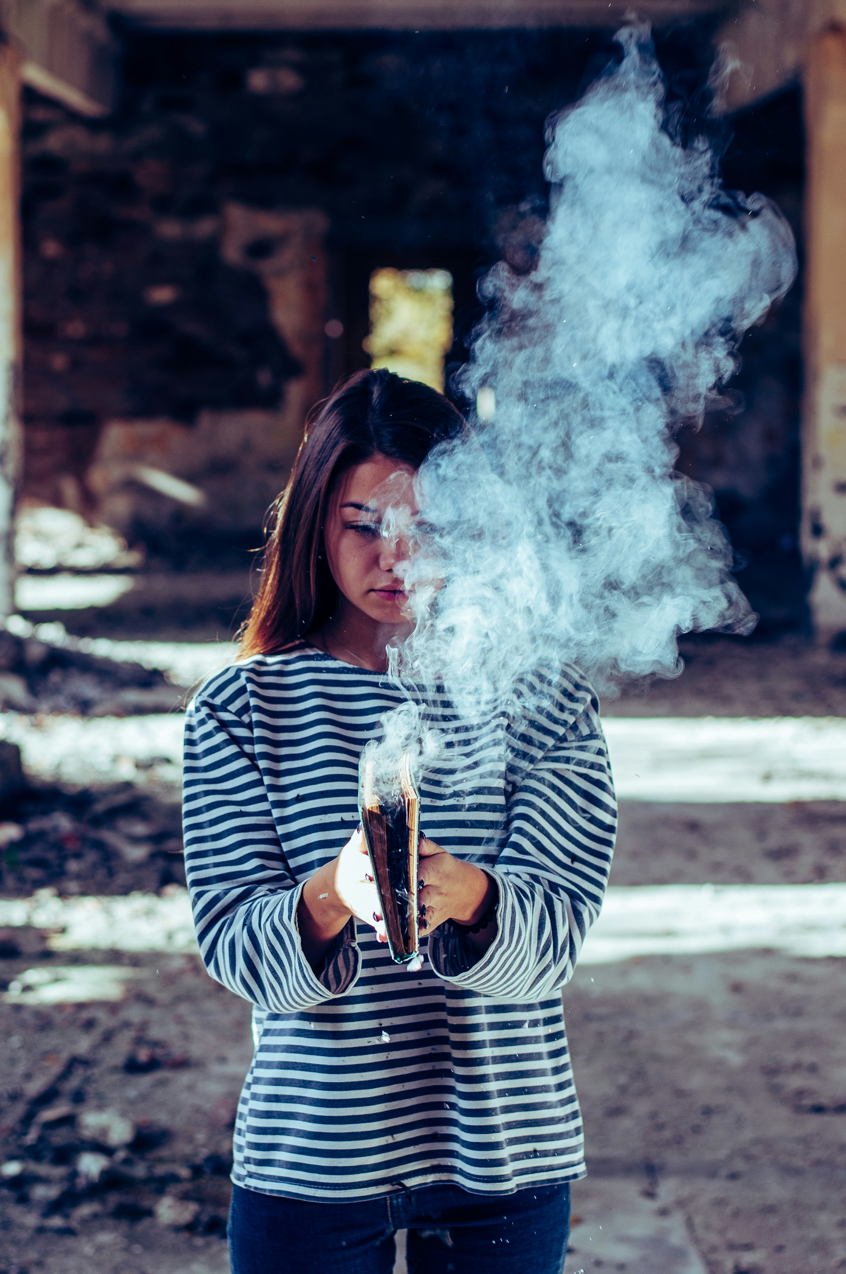 person holding book with smoke